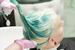 lavaggio verde capelli colore di giovane donna con shampoo nel capelli salone foto