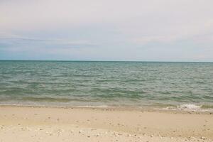impronte nel il sabbia, terra fuga di spiaggia e mare, blu onda e bianca sabbia foto