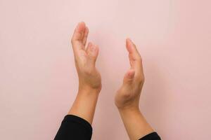 donna battimani mani isolato su rosa sfondo. vicino su di femmina mani applaudendo. foto