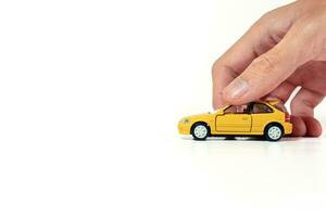 mano Tenere un' giallo giocattolo auto isolato su bianca sfondo. dopo alcuni modifiche. foto