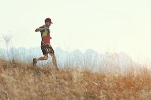 l'uomo corre in discesa tra i prati di montagna autunnali foto