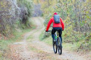 pedalare su strade sterrate nel bosco foto