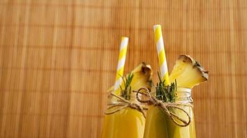 succo d'ananas in una bottiglietta. fette di ananas decorano la bevanda foto