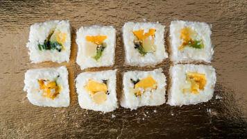 dessert sushi - roll con frutta su fondo oro foto