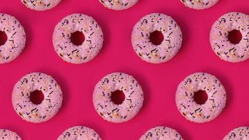 motivo creativo festivo di file di ciambelle su sfondo rosa foto