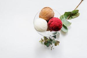 ciotola di vetro con palline colorate di gelato su sfondo bianco foto