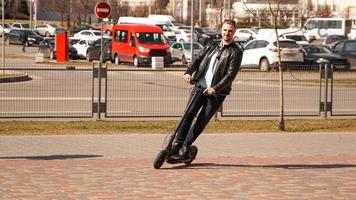 uomo moderno in sella a uno scooter elettrico in città foto