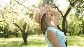 giovane donna con cappello di paglia nel giardino soleggiato foto