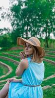 giovane donna con cappello di paglia nel giardino soleggiato