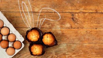 muffin fatti in casa con orecchie di coniglio dipinte. muffin e uova su un legno foto