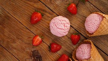 gelato alla fragola in un cono di cialda. bacche rosse e palline di gelato foto