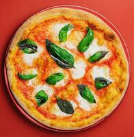 Pizza Margherita su rosso piatto e rosso sfondo foto