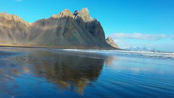 enorme vestrahorn montagne su spiaggia con famoso nero sabbia spiaggia su stokksnes penisola. atlantico oceano riva e colline la creazione di bellissimo orizzonte e maestoso scenario. palmare sparo. foto