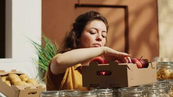 vegano donna nel sostenibile zero rifiuto supermercato odorare mele prima aggiungendo loro per shopping cestino. cliente nel Locale Quartiere drogheria negozio raccolta localmente cresciuto frutta foto