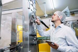 ingegnere maschio Lavorando impostare automatico macchina nel cibo bevanda industria fabbrica. foto