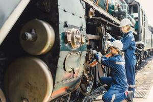 treno ingegnere squadra Lavorando servizio Manutenzione vecchio sporco Vintage ▾ classico vapore motore locomotiva nel treno riparazione laboratorio a treno stazione. foto