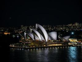 Sydney City Harbour con l'orizzonte del punto di riferimento del teatro dell'opera di notte in australia foto