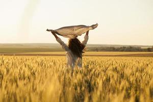 donna felice con il velo in mezzo al campo di grano maturo