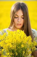 giovane donna con un mazzo di fiori di campo gialli