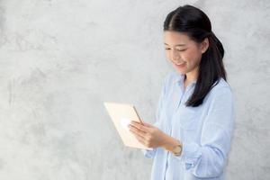 giovane donna asiatica touch computer tablet e sorridente.