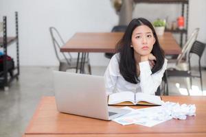 ritratto asiatico giovane donna che lavora online sul computer portatile. foto