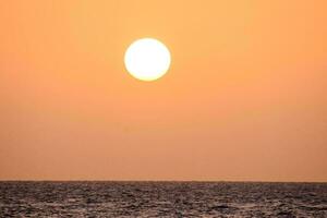 un' bellissimo tramonto al di sopra di il acqua foto