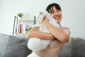 contento donna giocando con gatto nel accogliente vivente camera a casa. foto