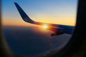 ala di un' aereo nel il cielo durante un' tramonto foto