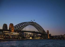 Sydney City Harbour Bridge e Circular Quay terminal passeggeri in Australia di notte foto