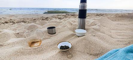 mare. piatti con tè sulla sabbia. vacanze estive. foto