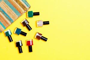 donna cosmetico Borsa con manicure e pedicure, luminosa gel vernici su giallo sfondo con copia spazio per il tuo design e testo. chiodo opera piatto posare concetto foto