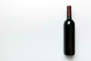 uno bottiglia di rosso vino su colorato tavolo. piatto posizione, superiore Visualizza wth copia spazio foto