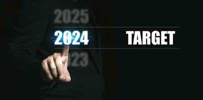 nuovo anno 2024 con obbiettivo. uomo d'affari puntamento per il numeri di il anno per impostato bersaglio per il In arrivo anno. foto
