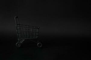 nero shoping carrello su nero sfondo per nero Venerdì shopping vendita concetto. foto