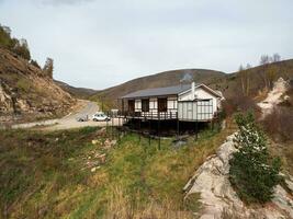 di legno ciglio della strada bar su un' montagna autostrada. Fumo a partire dal un' camino su il tetto di un' ciglio della strada ristorante. karachay-cherkessia. foto