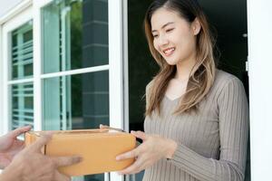 contento sorridente donna riceve scatole pacco a partire dal Corriere nel davanti Casa. consegna uomo Spedire consegnare esprimere. in linea acquisti, carta contenitori, porta via, postino, consegna servizio, pacchi foto