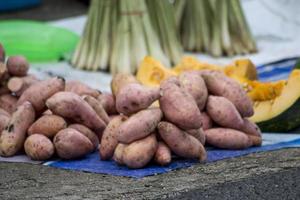 un mucchio di patate dolci sulla bancarella del venditore foto