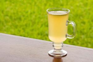 tè al limone con miele su tavola di legno su sfondo verde natura foto