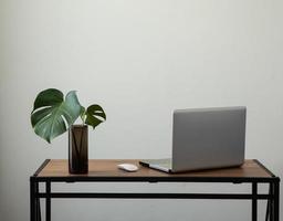 spazio di lavoro parete bianca minimal con notebook e scrivania foto