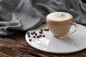 tazza di caffè cappuccino trasparente su fondo in legno foto