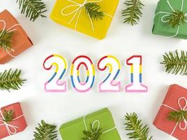 cartolina delle vacanze con rami di abete, scatole regalo e figure 2021 foto
