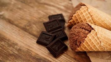 gelato al cioccolato in un cono di cialda su carta artigianale foto