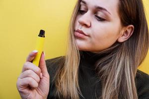 una ragazza fuma sigaretta elettronica usa e getta