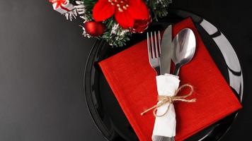 impostazione per la cena di Natale festiva sulla tavola nera con decorazioni foto