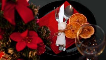 impostazione per la cena di Natale festiva sulla tavola nera con decorazioni foto