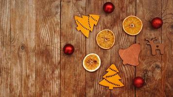 arance secche, palline rosse e statuine natalizie in legno foto