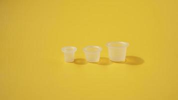 tre cappucci di plastica a inchiostro su sfondo giallo foto