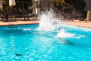 divertimento in piscina. tuffarsi nella piscina all'aperto foto