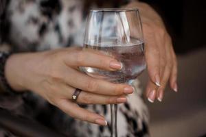 mano femminile che tiene un bicchiere di vino foto