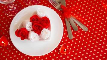 un piatto bianco con un coltello e una forchetta su uno sfondo rosso brillante foto